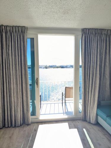 a room with a large window with a view of the water at Inn on Destin Harbor, an Ascend Collection Hotel in Destin