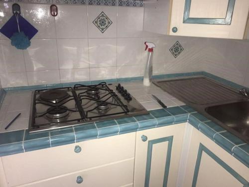 a kitchen counter with a stove and a sink at Villa con vista sull’arcipelago della Maddalena in Palau