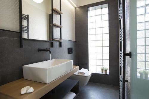 a bathroom with a white sink and a toilet at Inorato - Luxury Villa with Private Swimming Pool in Kalamitsi