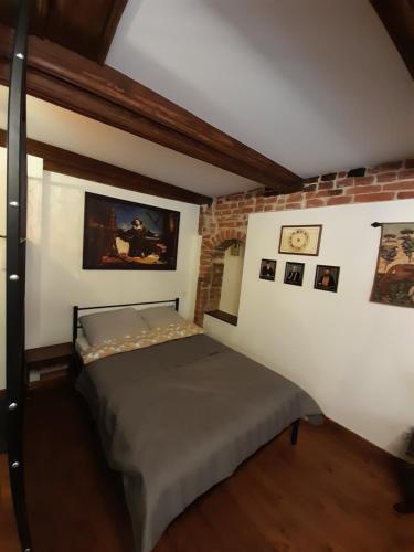a bedroom with a bed and a brick wall at Apartament Witrażysty A.D. 1555 in Toruń