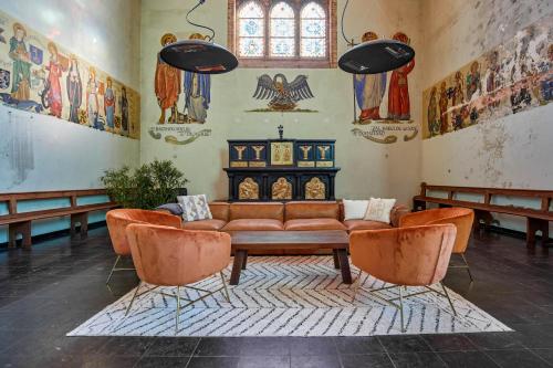 a living room with a couch and two chairs at Sleeping in a Church - Bed & Bar Tolomeus in Diksmuide