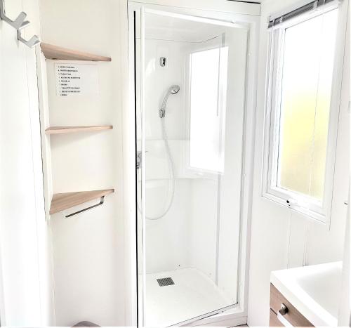 ein Badezimmer mit Dusche mit Glastür in der Unterkunft Bungalow convivial à Saint-Jean-de-Monts avec piscine partagée in Saint-Jean-de-Monts