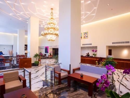 a lobby with a chandelier and tables and chairs at Poulo Wai Hotel & Apartment in Phnom Penh