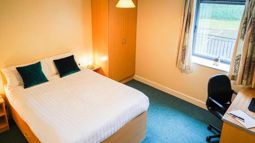 a bedroom with a bed and a desk and a window at The Grove in Sligo