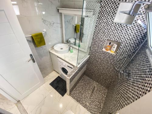 a bathroom with a shower with a sink and a mirror at Cosy Apartment in La Marsa - 2 bed 1 Bath in La Marsa