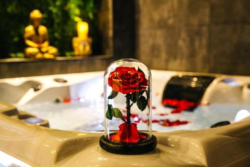 a red rose in a glass dome on a sink at Loveroom intimiste et haut de gamme à 30 min de Toulouse in Lagrâce-Dieu