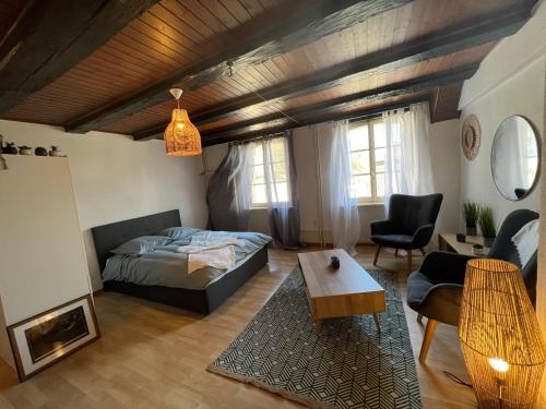 a bedroom with a bed and a table in a room at Meunier tu dors ! au pied du Moulin in Porrentruy