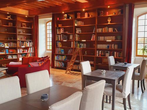 un salon avec une bibliothèque avec tables et chaises dans l'établissement Domaine de la Brette, à Condom