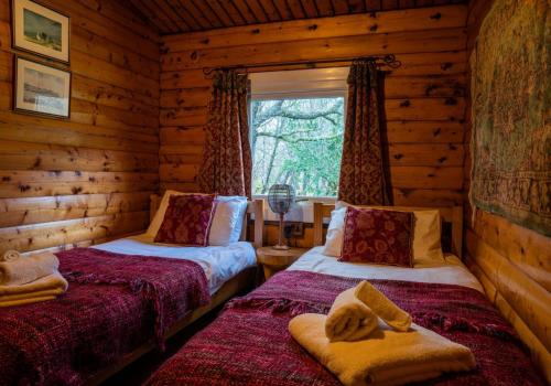 a bedroom with two beds in a log cabin at Raasay in Kyle of Lochalsh