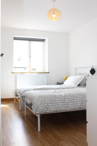 a white bedroom with a bed and a window at Lux Apartment in Bangor