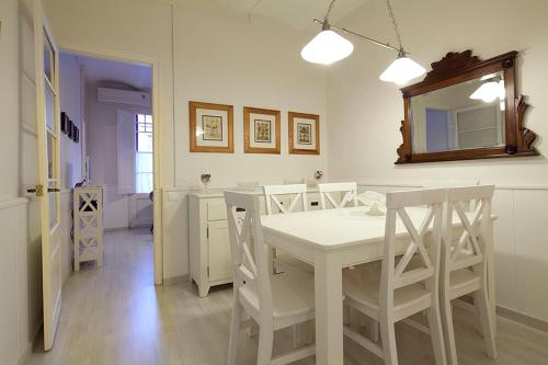 a white dining room with a white table and chairs at Stay U-nique Apartments Gaudi II in Barcelona