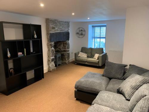 a living room with a couch and a fireplace at Cosy cottage in picturesque Snowdonia with stunning views of the Moelwyn mountains in Blaenau-Ffestiniog