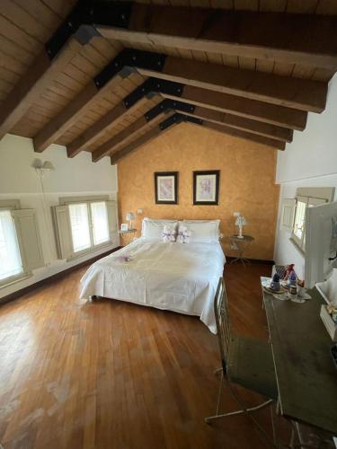 a large bedroom with a large white bed and wooden floors at B&B Casa del Teatro in Mantova