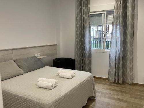a bedroom with a bed with two towels on it at alojamiento saturno1 in Conil de la Frontera