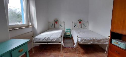 two twin beds in a room with a window at Casa Magana em Grândola in Grândola