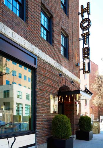 Un edificio de ladrillo rojo con un cartel. en Neptune, an Ash Hotel, en Providence