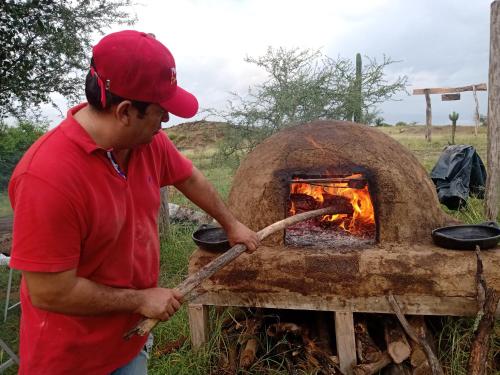 Un homme cuisine de la nourriture dans un four en briques dans l'établissement Mirador Valle de la Tatacoa, à Villavieja