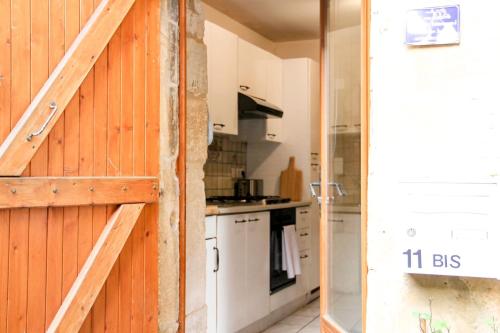 een keuken met houten wanden en een schuifdeur bij La Casa de Pipo Au cœur de Sarlat in Sarlat-la-Canéda