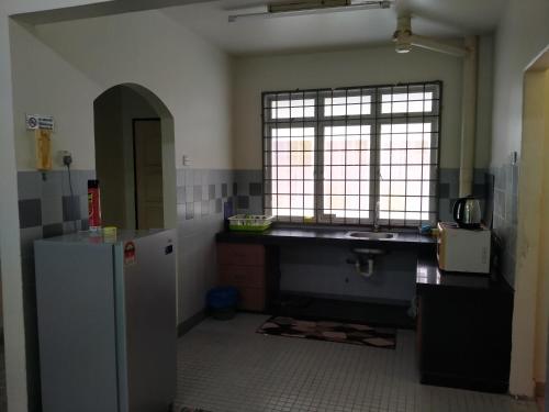 a kitchen with a sink and a refrigerator at Family Beach Condo PD at Cocobay Resort Condominium in Port Dickson