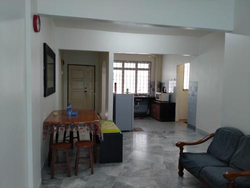 una cucina e un soggiorno con tavolo e divano di Family Beach Condo PD at Cocobay Resort Condominium a Port Dickson