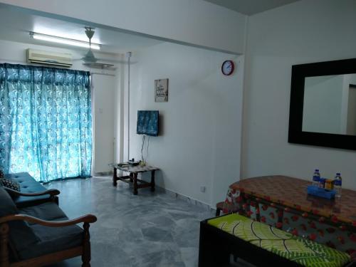 a living room with a couch and a window at Family Beach Condo PD at Cocobay Resort Condominium in Port Dickson