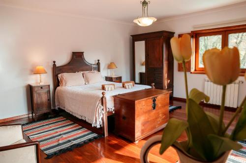 una camera con un letto, un comò in legno e un tavolo di Casa das Flores ad Amares