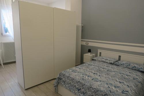 1 dormitorio con 1 cama y armario blanco grande en B&BO SAGO, en Bolonia