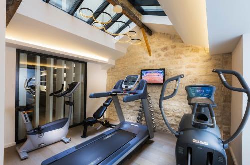 a gym with two exercise bikes and a treadmill at H&ocirc;tel Moli&egrave;re in Paris