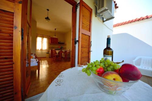a bowl of fruit on a table with a bottle of wine at Studios Calvinos in Marathokampos