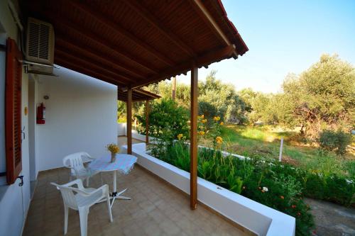 a patio with a table and chairs and a garden at Studios Calvinos in Marathokampos