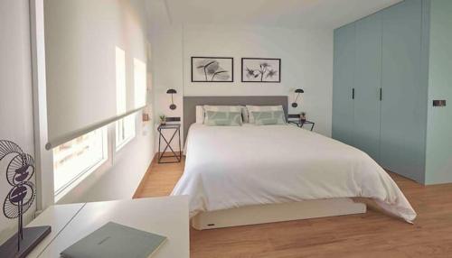 um quarto branco com uma cama grande e uma janela em Suite con terraza en el centro de Alicante em Alicante