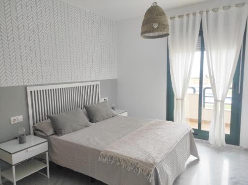a bedroom with a bed and a large window at Dream Sea Golf & Beach in Benalmádena