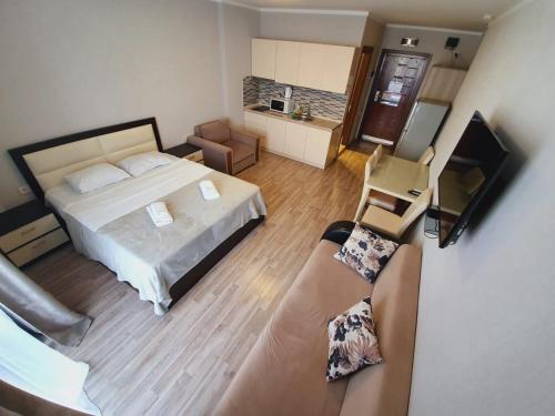 een grote slaapkamer met een bed en een bank bij Royal Apartments in Batoemi