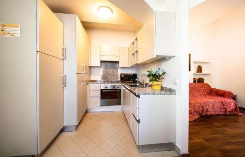 een kleine keuken met witte kasten en een aanrecht bij Schlossquadrat Apartment 16 in Wenen