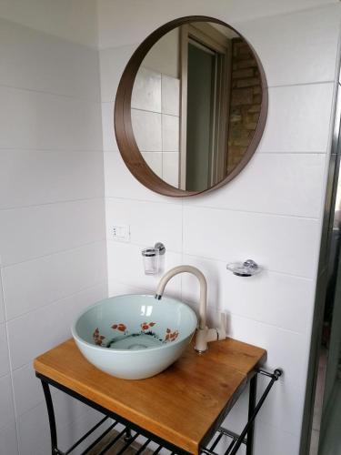 a bathroom with a bowl sink and a mirror at la Mafalda in Oltrepo in Codevilla