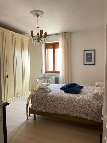 a bedroom with a bed and a chandelier at La Signora Dei Fiori in Gubbio