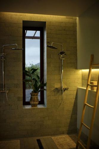 a bathroom with a window and a plant in a shower at Villa - Cantinho do Paraíso in Santo Espírito