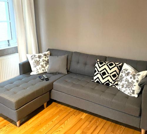 a gray couch in a living room with pillows at Uriges Ferienhaus in der Altstadt von Saarburg mit Sauna, Kinderspielecke, 1000Mbit Wlan, 1 Minute vom Wasserfall entfernt in Saarburg