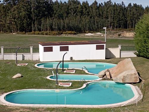 un grupo de tres piscinas en un campo en Apartamento, Ático, Casa, PLAYA LAS CATEDRALES, en San Cosme de Barreiros