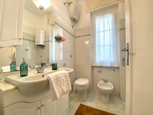 bagno bianco con lavandino e servizi igienici di CasaViva- Ampio appartamento nei vicoli di Genova a Genova