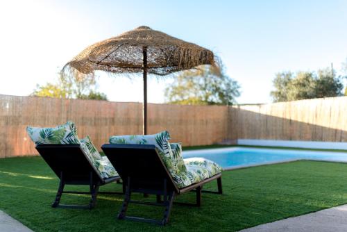 two chairs and an umbrella next to a swimming pool at Villa Colorín in Córdoba