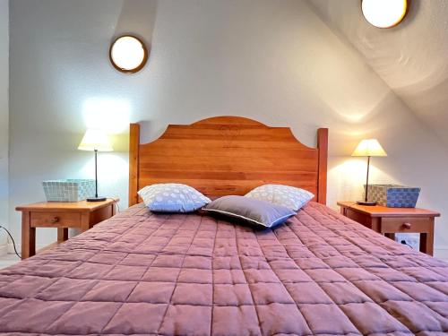 a bedroom with a large purple bed with two lamps at T2 bis 40M2 5P. Vue. Balcon. Parking. Piscine été. in Cauterets