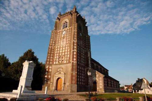a building with a tower with a clock on it at Maison charmante à Saint-Blimont avec jardin in Saint-Blimont