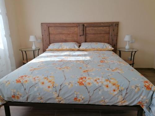 1 cama con edredón de flores y 2 lámparas en la Mafalda in Oltrepo, en Codevilla