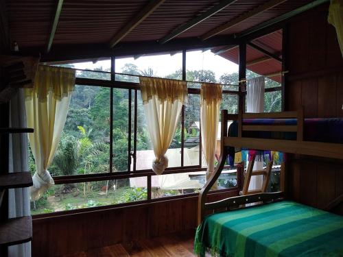 een slaapkamer met een bed en een groot raam bij Nido de Vida in San Miguel de los Bancos