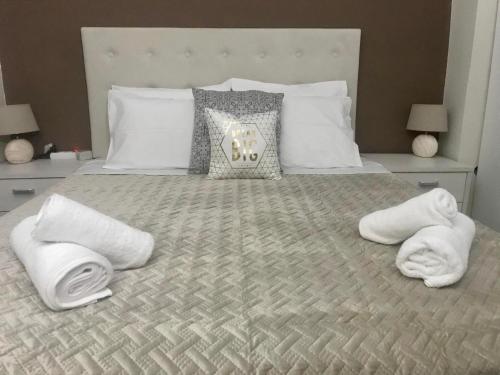 a bedroom with a bed with towels on it at Sabbia Beach House in Alykes