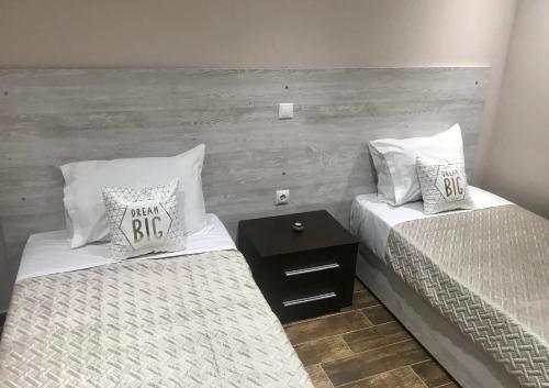 two twin beds in a room with a wooden wall at Sabbia Beach House in Alykes