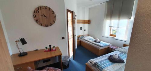 a room with two beds and a clock on the wall at Alte Post zu Stetzsch in Dresden