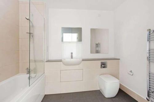 y baño con aseo, lavabo y ducha. en Apek Apartment en Londres