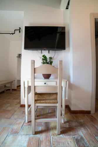 a white desk with a chair and a tv on a wall at La Residenza dei Priori in Tarquinia